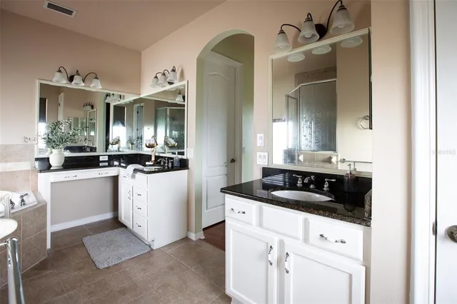 a bathroom with a granite countertop sink a bathtub and shower
