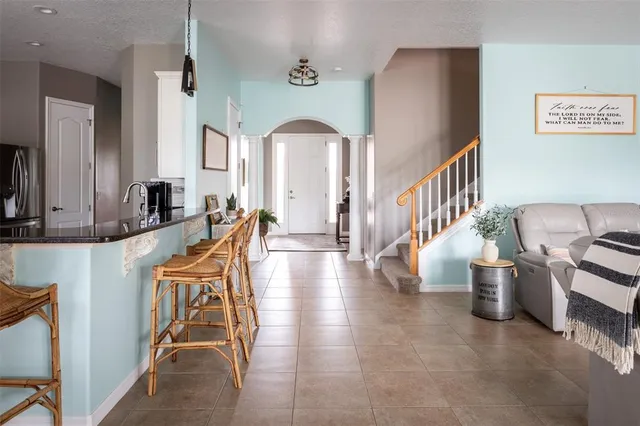 a kitchen with stainless steel appliances granite countertop a stove top oven a sink a dining table and chairs with wooden floor