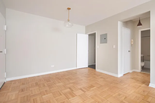 a dining room with wooden floor a glass table and chairs