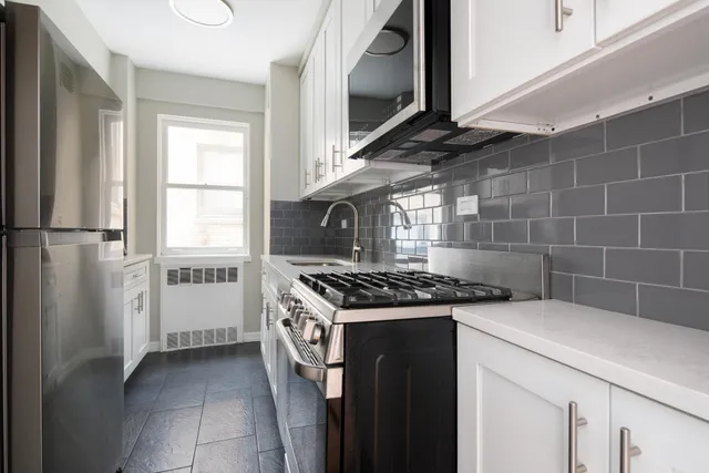 an empty room with windows and ceiling fan