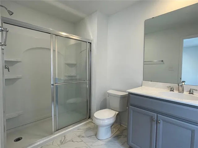 a bathroom with a toilet a sink and shower