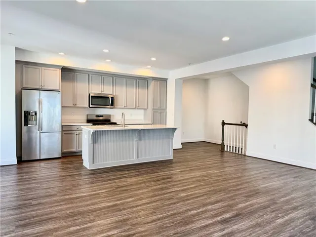 a view of kitchen with wooden floor and electronic appliances