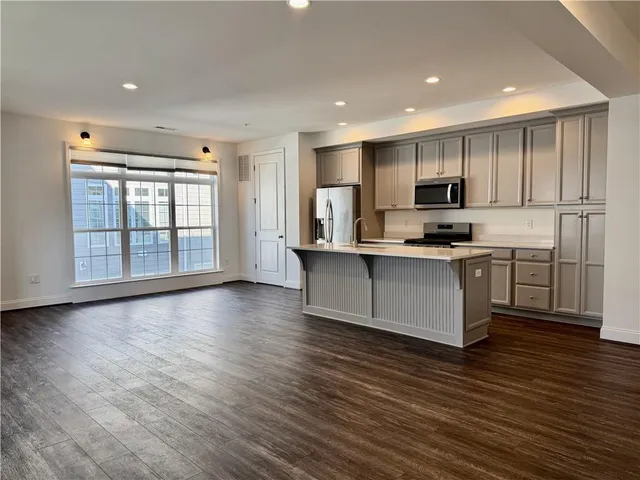 a large kitchen with stainless steel appliances granite countertop a stove a sink and a microwave