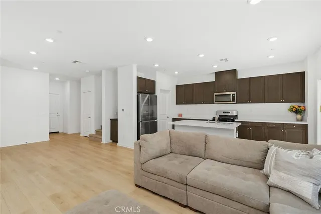 a view of kitchen with kitchen island stainless steel appliances refrigerator stove top oven and cabinets