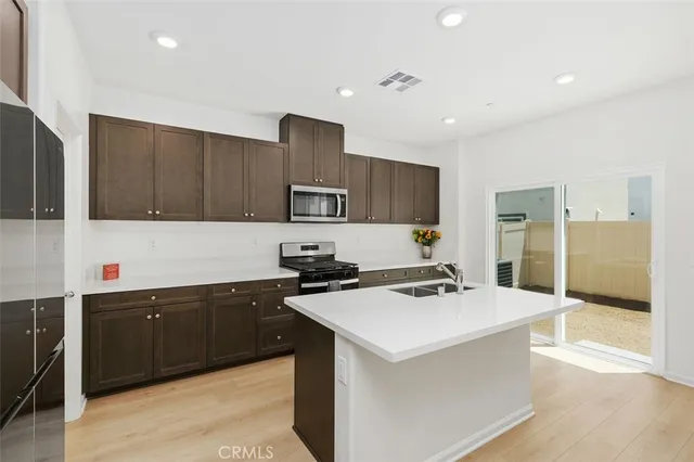 a kitchen with stainless steel appliances a sink stove and refrigerator