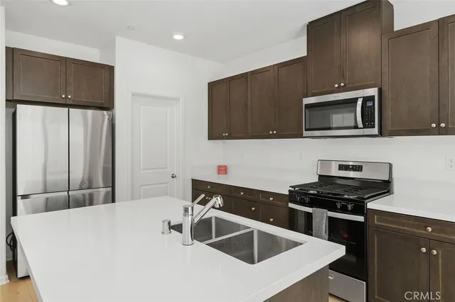 a kitchen with a sink and steel appliances