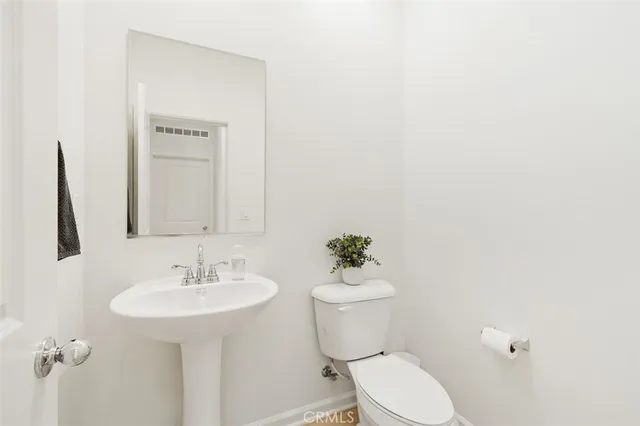 a bathroom with a sink toilet and a mirror