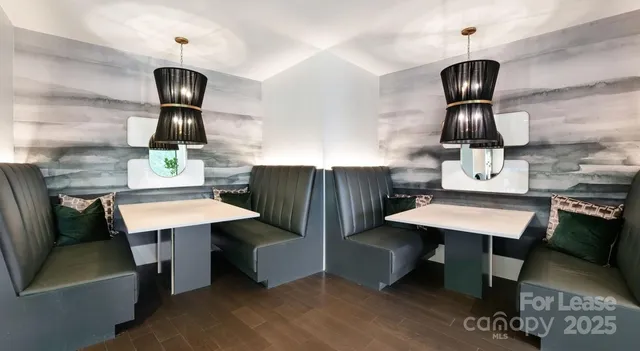 a kitchen with stainless steel appliances kitchen island a table chairs in it and wooden floors