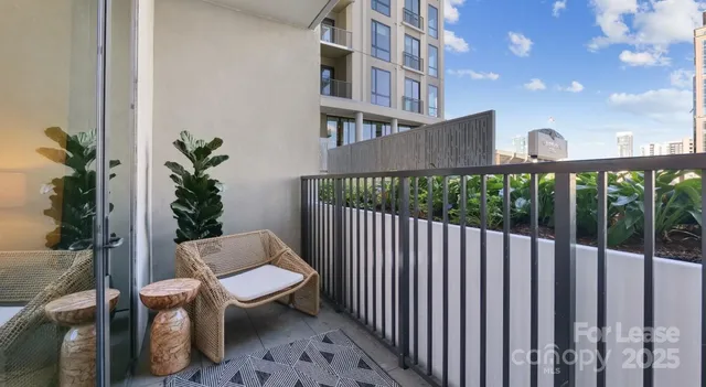 a view of a balcony with chairs and wooden fence