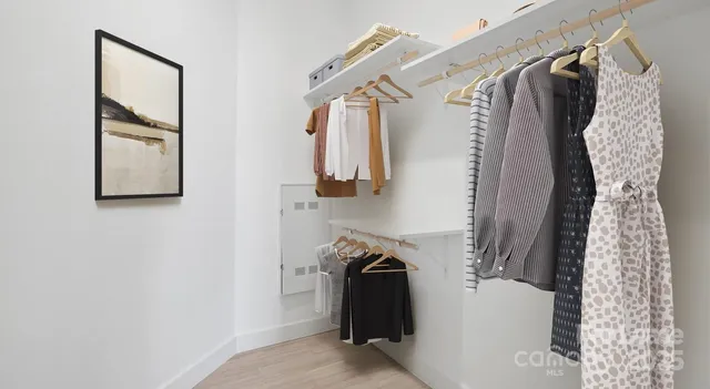 a view of walk in closet with clothes and shoes