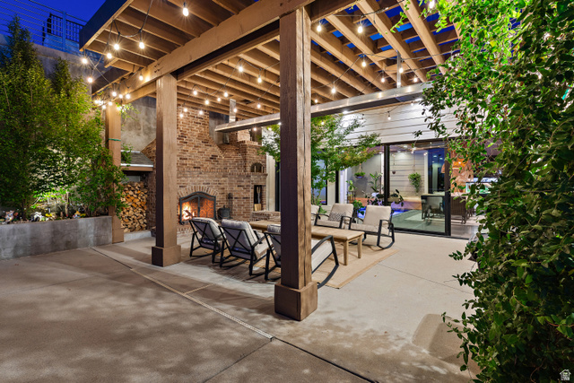 912 North Loafer Canyon Road Elk Ridge, UT 84651 - Photo 87 of 98 Expansive patio featuring a wood pergola, string lighting, a large brick fireplace, and mature landscaping
