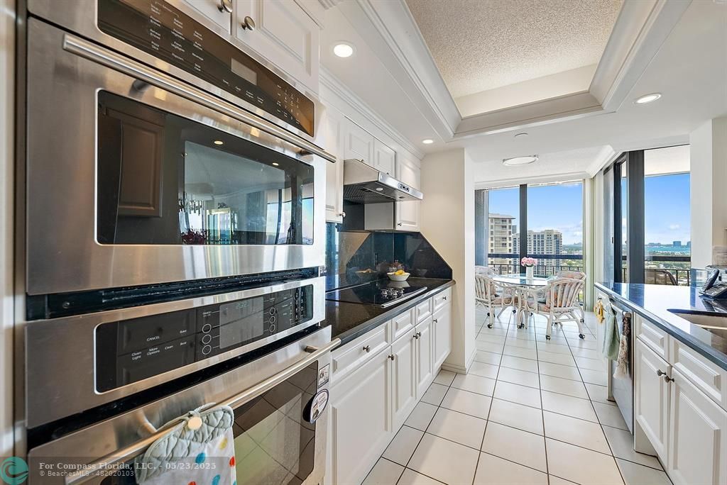 4100 North Ocean Drive, Unit 1804 Riviera Beach, FL 33404 - Photo 6 of 30 a kitchen with stainless steel appliances kitchen island granite countertop a stove top oven a sink and cabinets