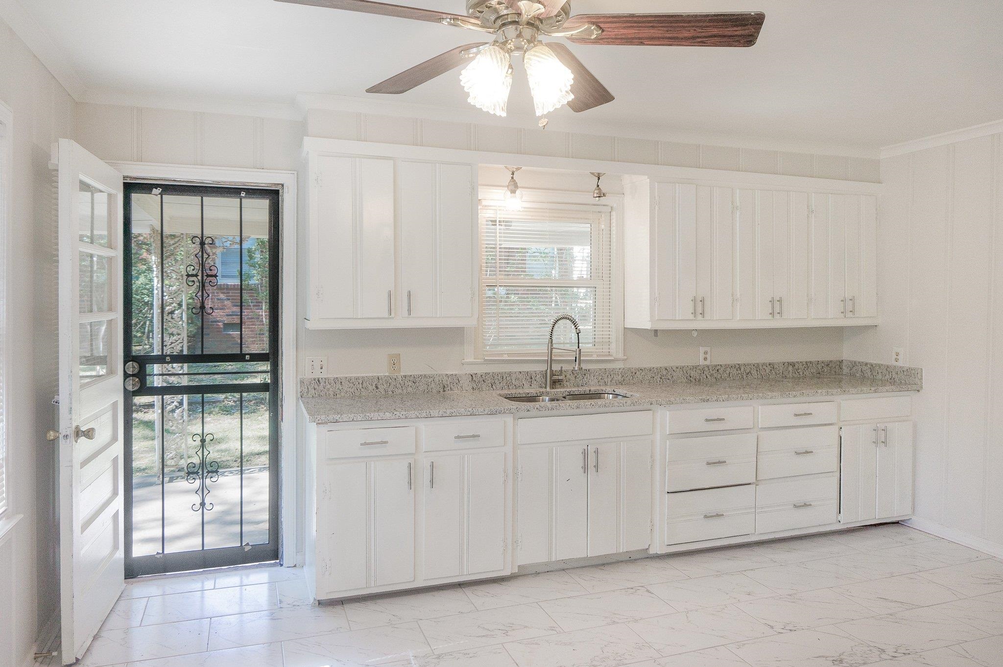 4506 Faronia Road Memphis, TN 38116 - Photo 2 of 15 Kitchen with light marble finish flooring, white cabinets, crown molding, and light stone counters