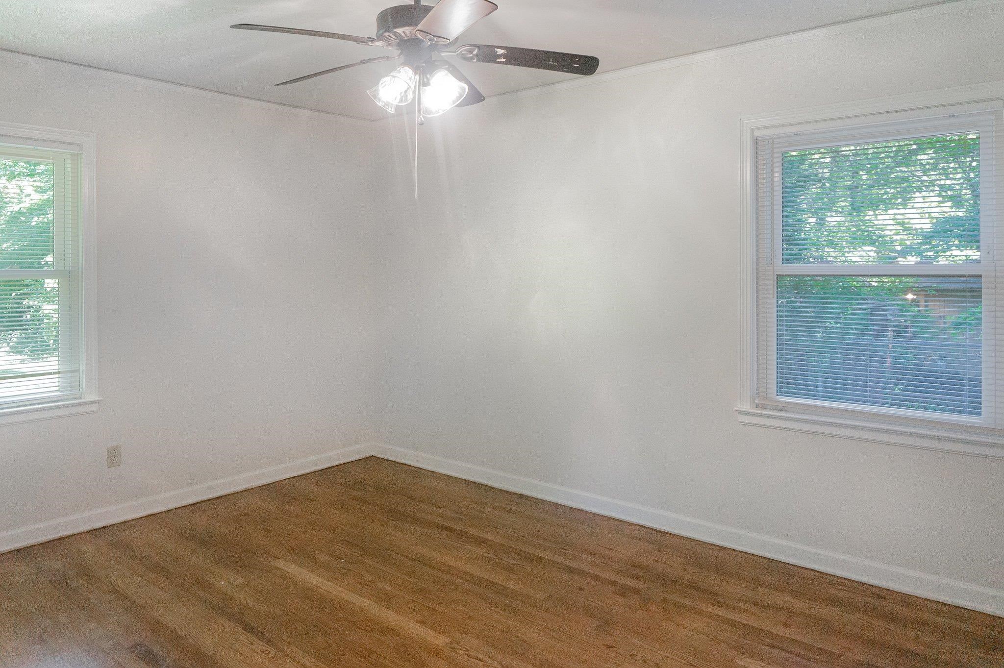 4506 Faronia Road Memphis, TN 38116 - Photo 6 of 15 Empty room with healthy amount of natural light, wood finished floors, ceiling fan, and ornamental molding