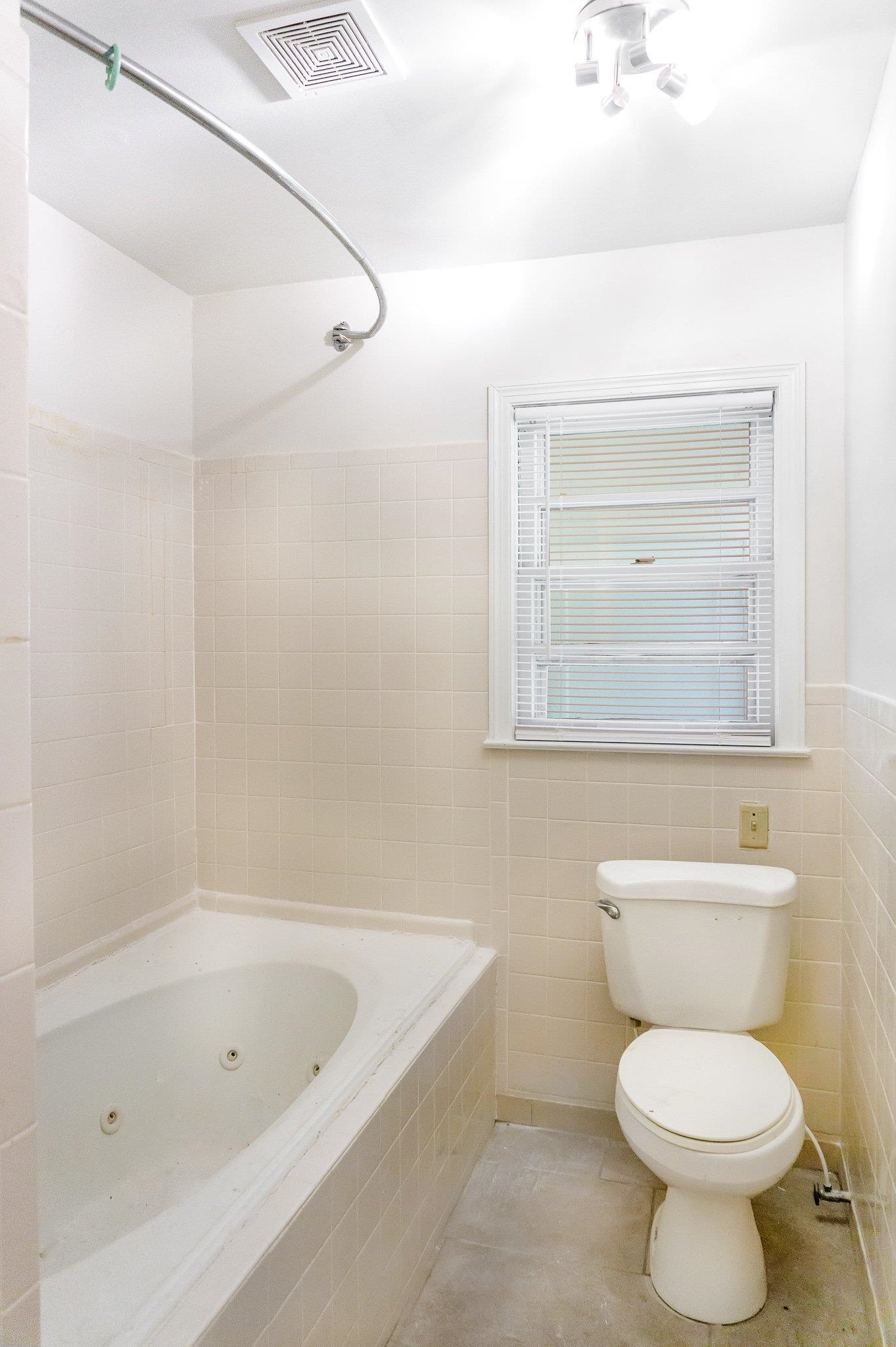 4506 Faronia Road Memphis, TN 38116 - Photo 8 of 15 Bathroom with a combined bath / shower with jetted tub, tile patterned floors, and tile walls