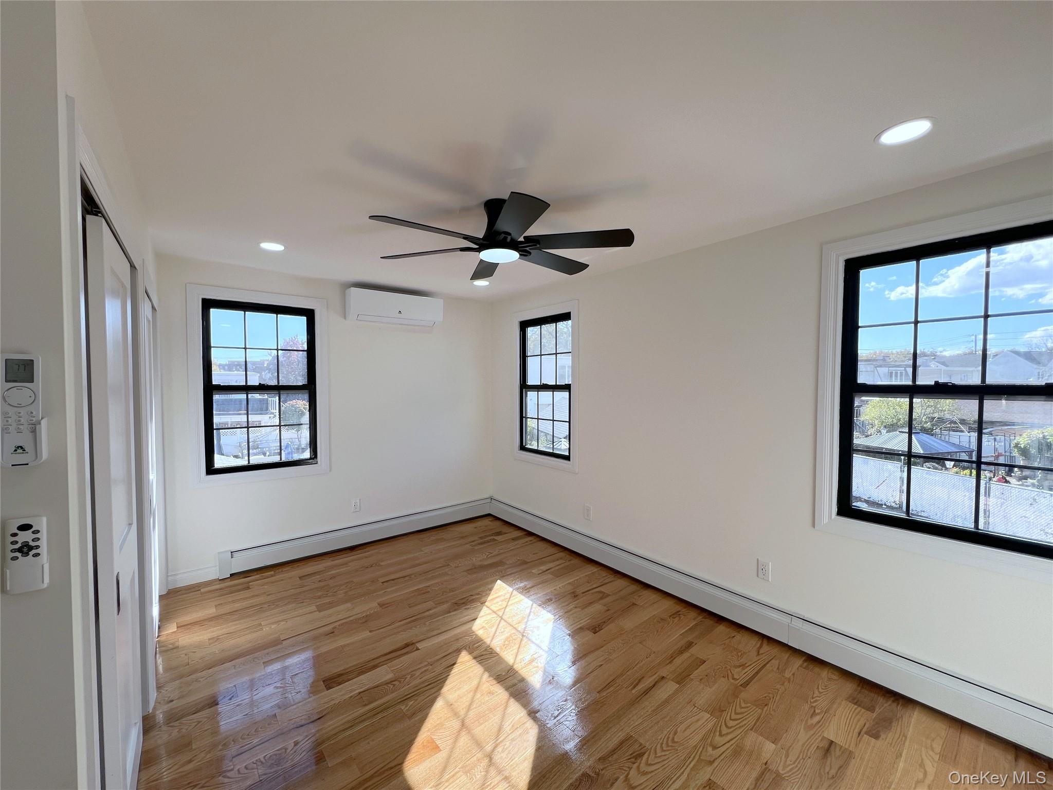 66-08 73rd Place Queens, NY 11379 - Photo 6 of 17 a view of empty room with wooden floor and fan