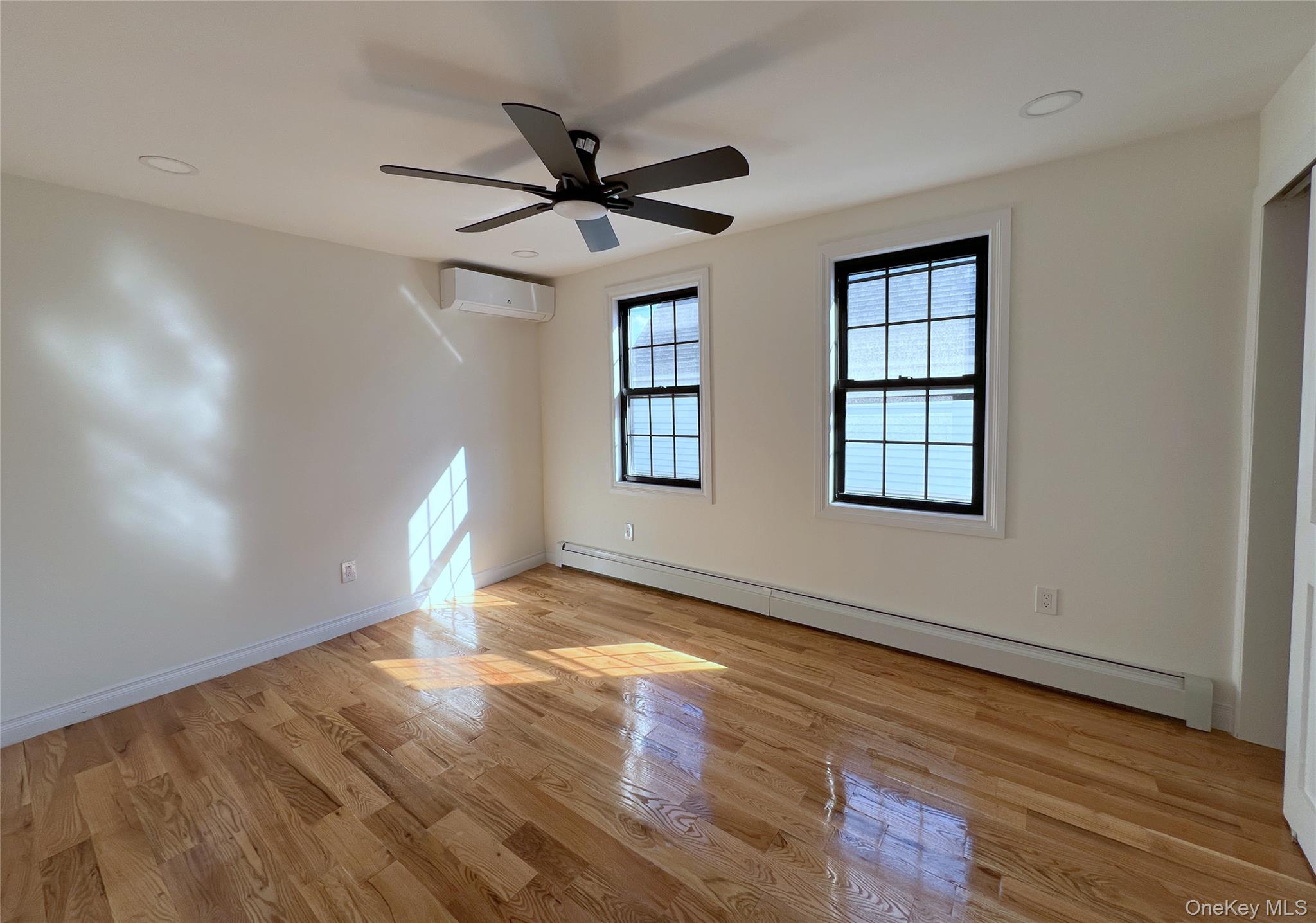 66-08 73rd Place Queens, NY 11379 - Photo 7 of 17 a view of empty room with wooden floor and fan