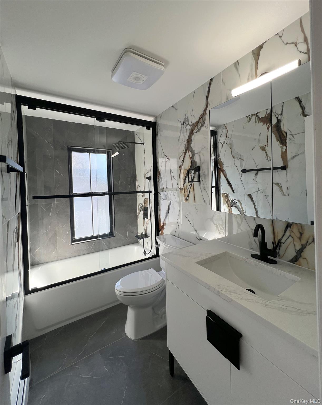 66-08 73rd Place Queens, NY 11379 - Photo 9 of 17 a bathroom with a sink a toilet and shower