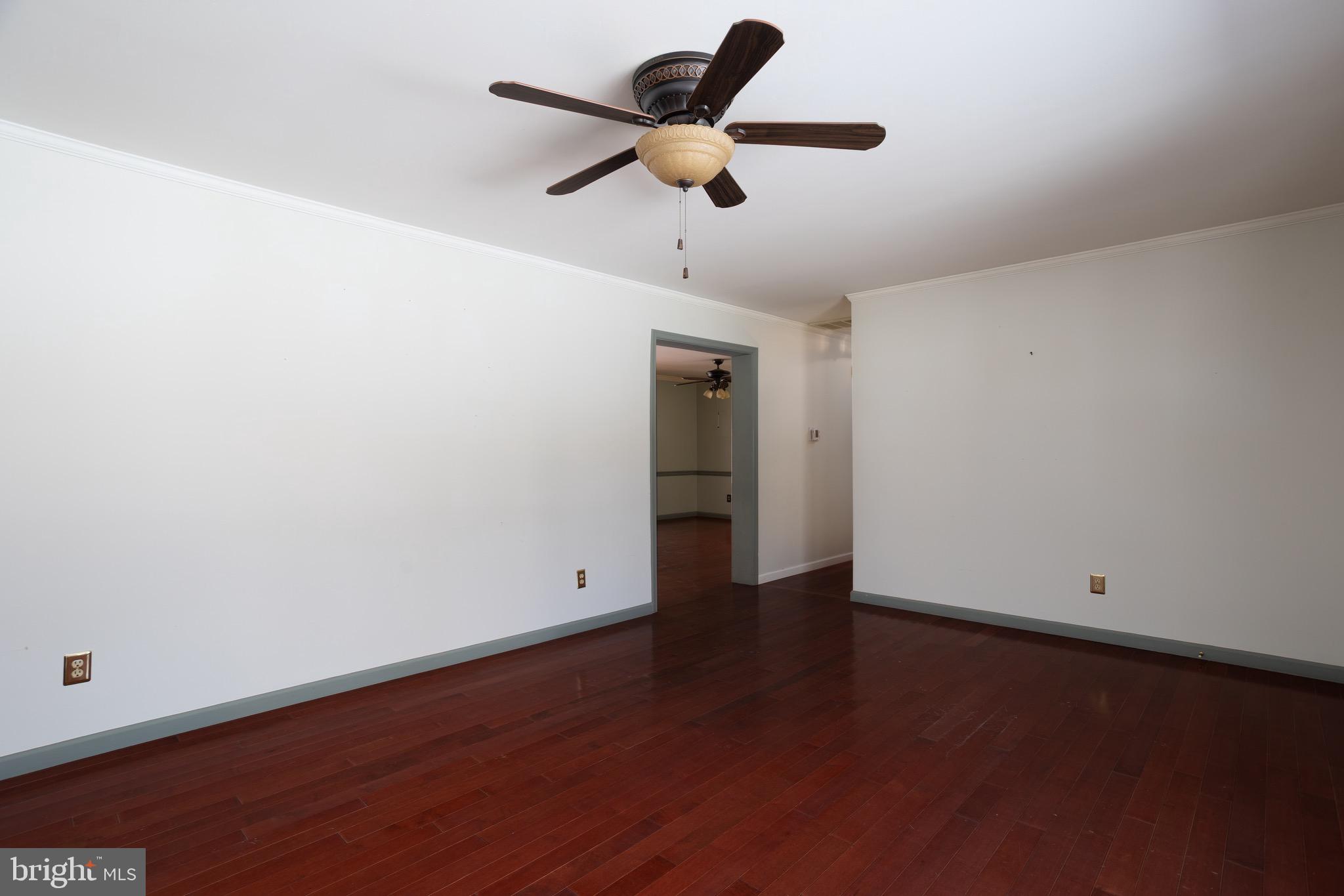 25999 Fox Grape Road Greensboro, MD 21639 - Photo 9 of 23 an empty room with wooden floor ceiling fan and window