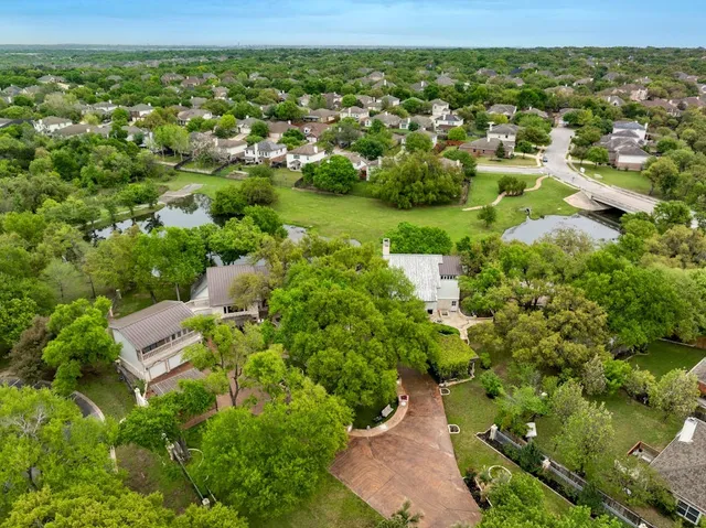 an aerial view of residential houses with outdoor space and trees