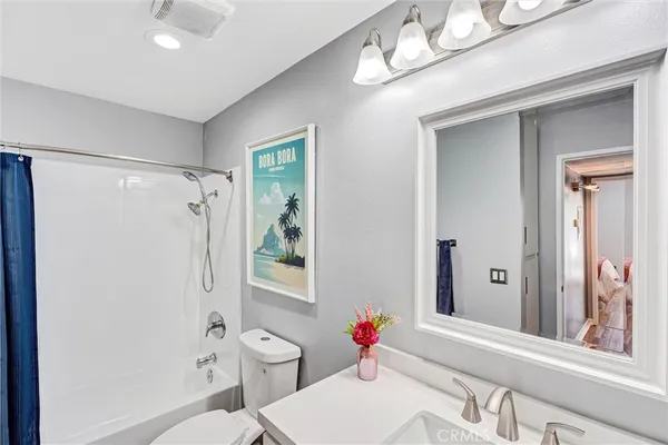 a bathroom with a sink vanity mirror and toilet