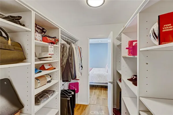 a view of walk in closet with clothes and shoes