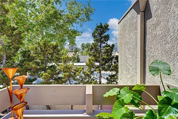 view of balcony with two plants and a bench