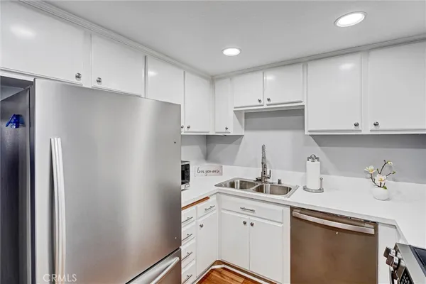 a kitchen with a sink a refrigerator and cabinets