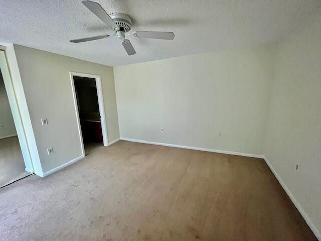 1817 18th Court, Unit 1817 Jupiter, FL 33477 - Photo 9 of 18 an empty room with a ceiling fan and carpet