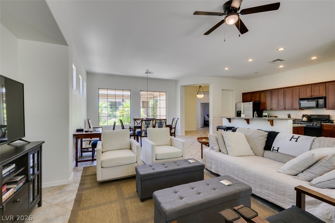 8 Kennesaw Road Henderson, NV 89052 - Photo 19 of 44 An open-concept living space with a kitchen island and natural light from large windows.