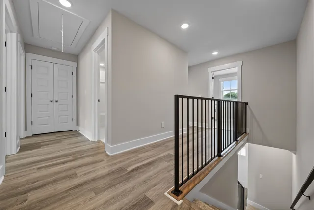 a view of a hallway with wooden floor and staircase