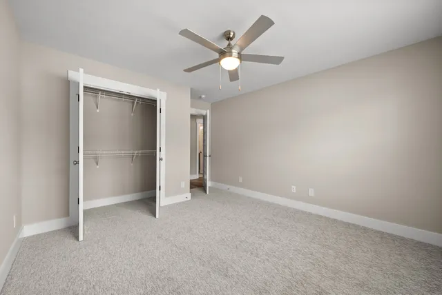 an empty room with closet and windows