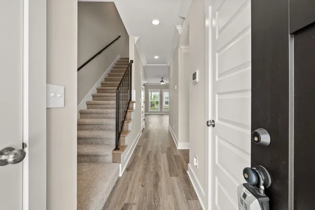 a view of a hallway with wooden floor and staircase