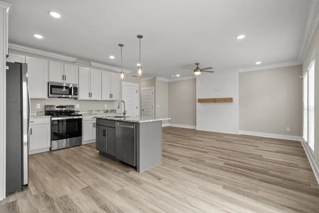 a kitchen with stainless steel appliances kitchen island granite countertop a stove a sink and a refrigerator