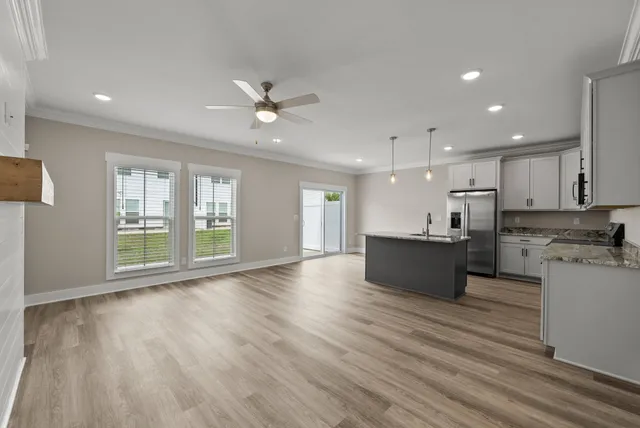 a view of kitchen with refrigerator stove and wooden floor