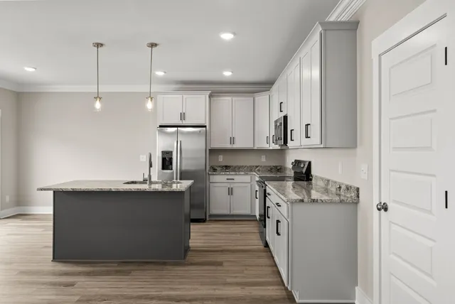 a kitchen with stainless steel appliances granite countertop a sink a stove and a refrigerator