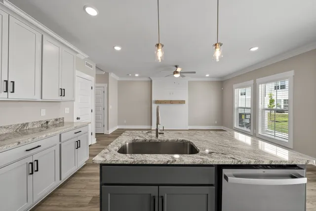 a kitchen with stainless steel appliances granite countertop a sink a oven a refrigerator and white cabinets