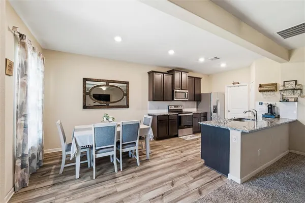 a living room with furniture a flat screen tv and kitchen view