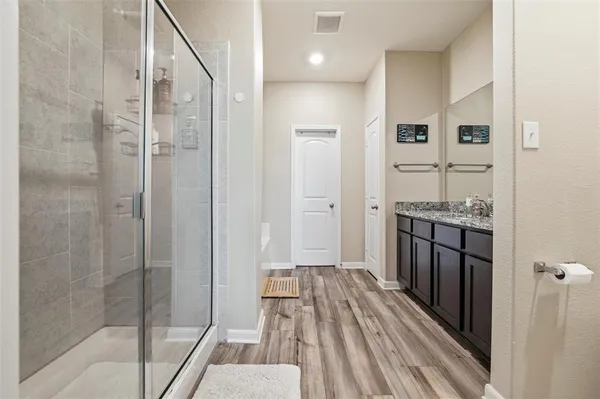 a bathroom with a sink and glass door shower