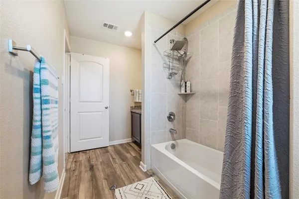 a bathroom with a tub a window and a shower