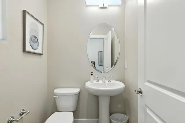 a bathroom with a toilet sink and mirror