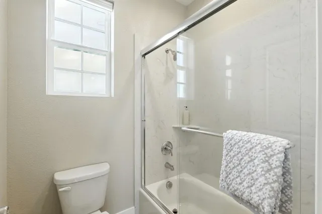a bath room with a toilet a bath tub and a shower