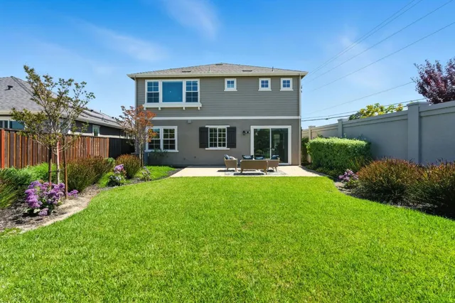 a view of a house with backyard sitting area and garden