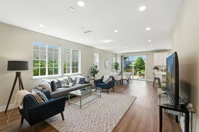 a living room with furniture flat screen tv and a large window