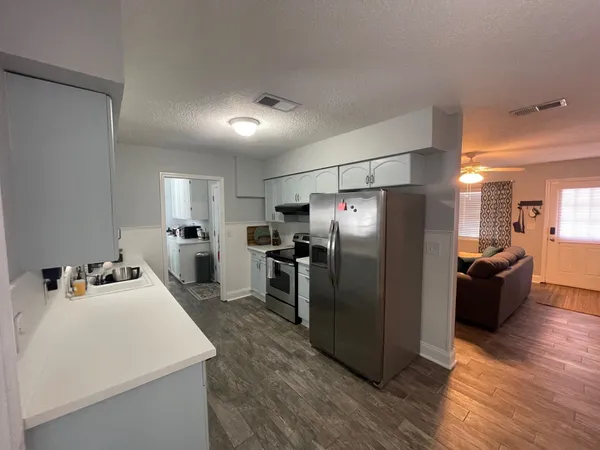 a kitchen with refrigerator cabinets and wooden floor