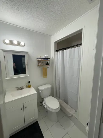 a bathroom with a toilet a sink and mirror