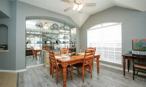 a dining room with furniture a chandelier and wooden floor