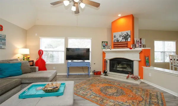 a living room with furniture a flat screen tv and a fireplace