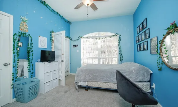 a bedroom with bed and a flat tv screen on dresser