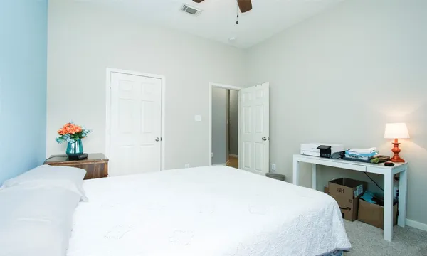 a bedroom with a bed and a desk in it